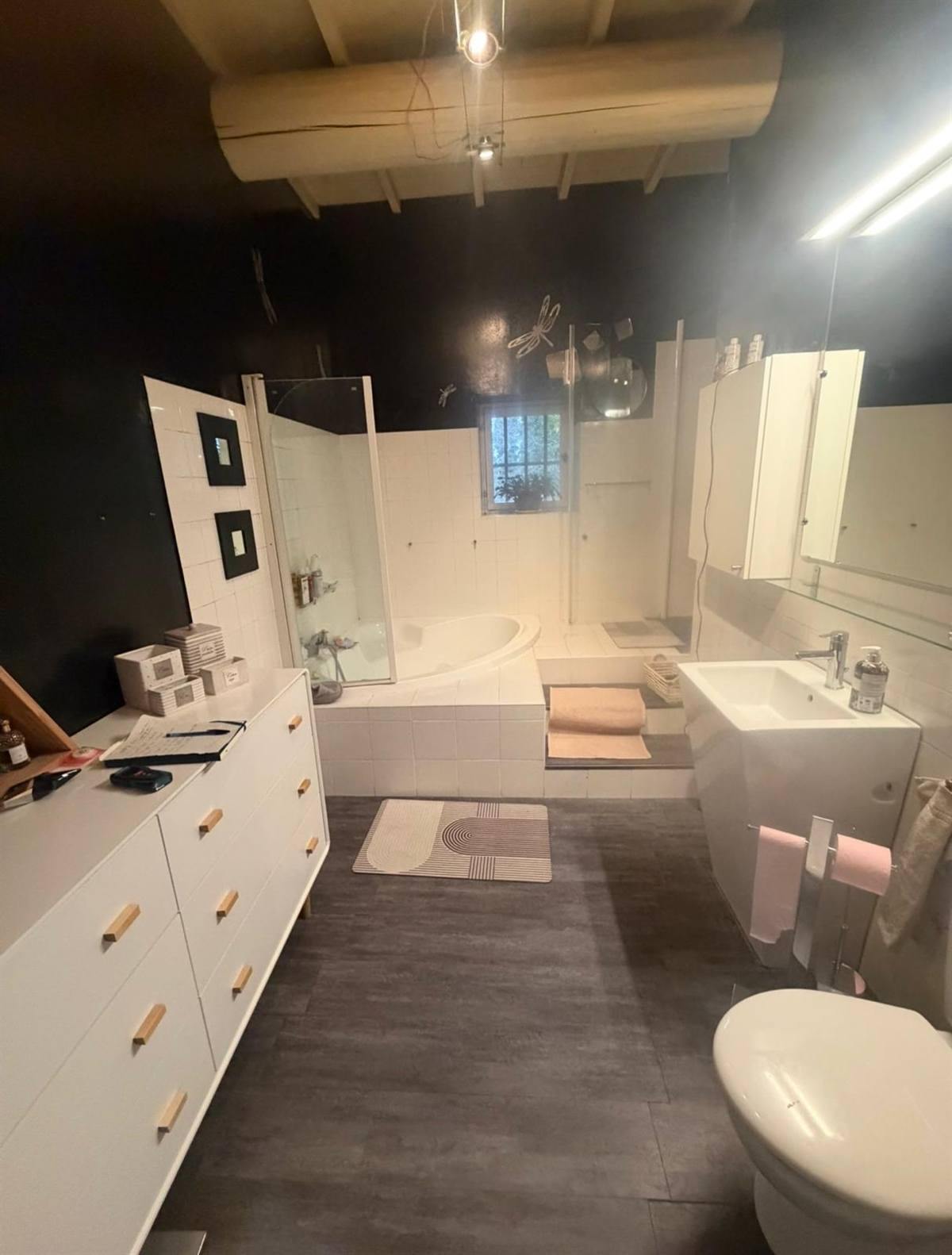 La salle de bain avant les travaux : murs sombres et sol gris